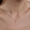 Gold anchor necklace on woman's neck - dainty nautical layering necklace