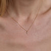 Gold diamond cross necklace on neck - delicate faith-inspired layering necklace